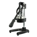 Black cast iron manual juicer with stainless steel strainer on kitchen counter