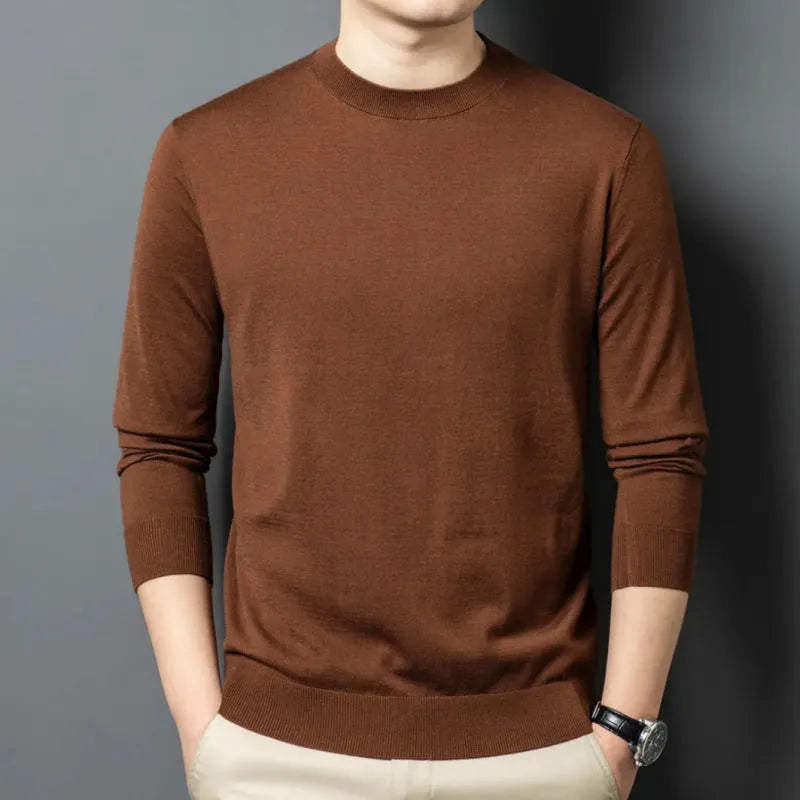 Man wearing a round neck grey wool blend sweater with long sleeves.
