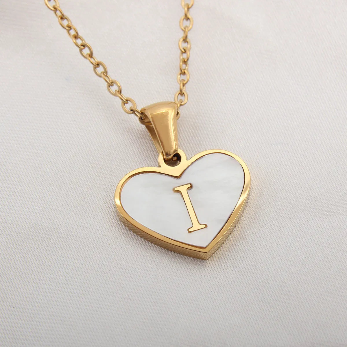 Gold plated heart-shaped white shell pendant personalised initial necklace on a stainless steel chain.