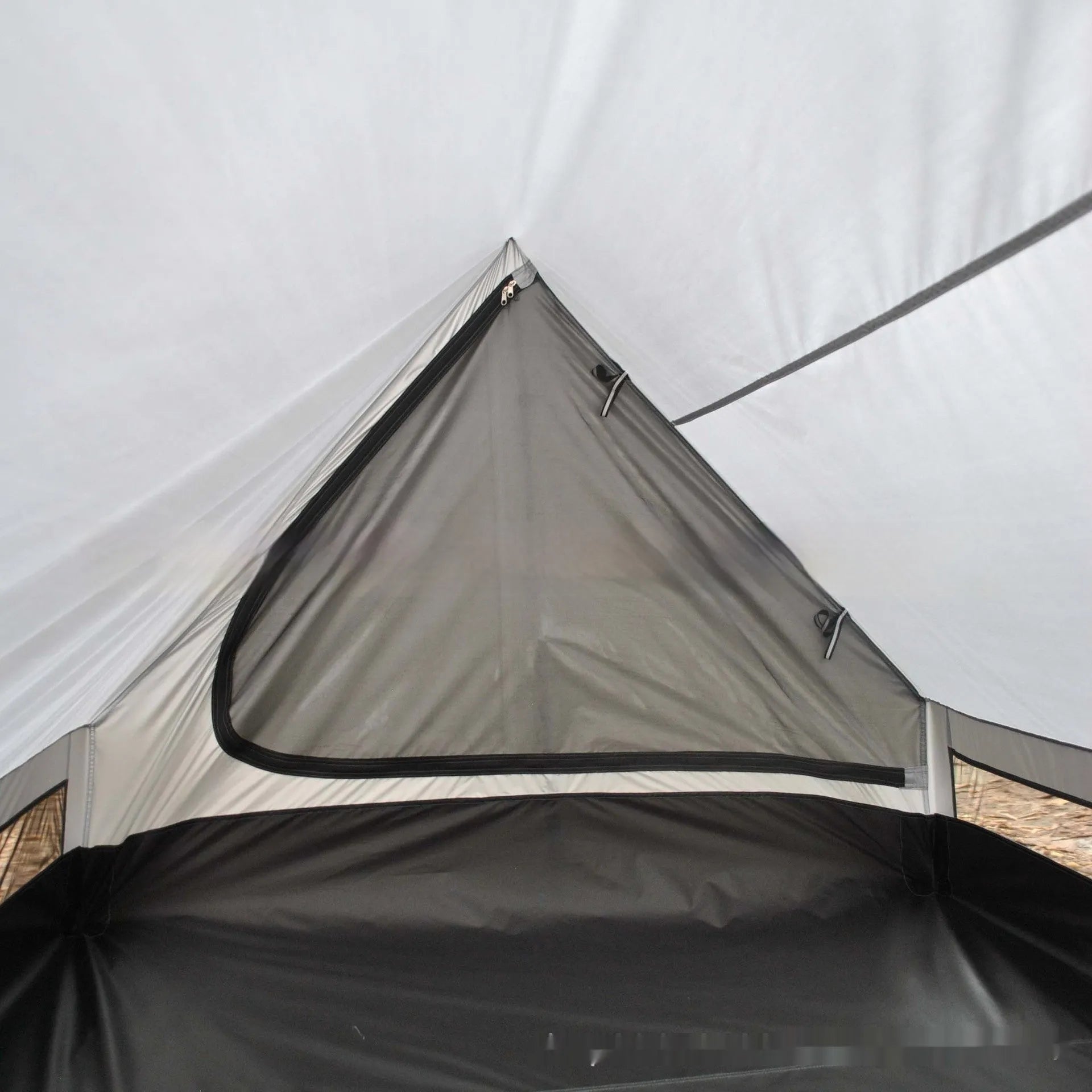 Brown A-line cabin tent pitched with hiking poles as structural support showing spacious interior for 2-3 people