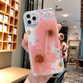 Floral pattern iPhone case in pink or yellow colour on a mobile phone