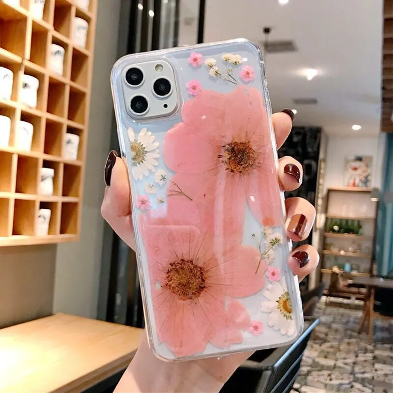 Floral pattern iPhone case in pink or yellow colour on a mobile phone