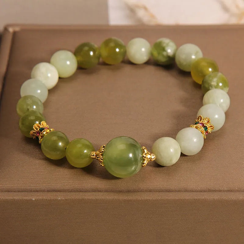Xiuyan jade green women's bracelet with an original bangle design on a plain background.