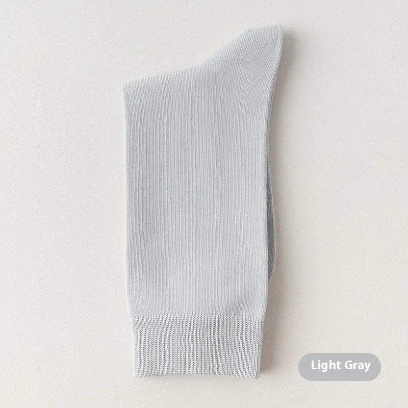Mid-calf men's socks in solid colours made from combed cotton, shown in a stack.