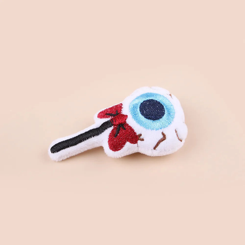 Small plush cat teaser toy with candy, eyes and skull attachments on lightweight handle