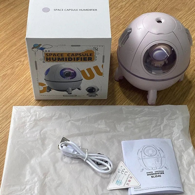 Purple astronaut-shaped USB desktop humidifier with colourful LED light on a desk