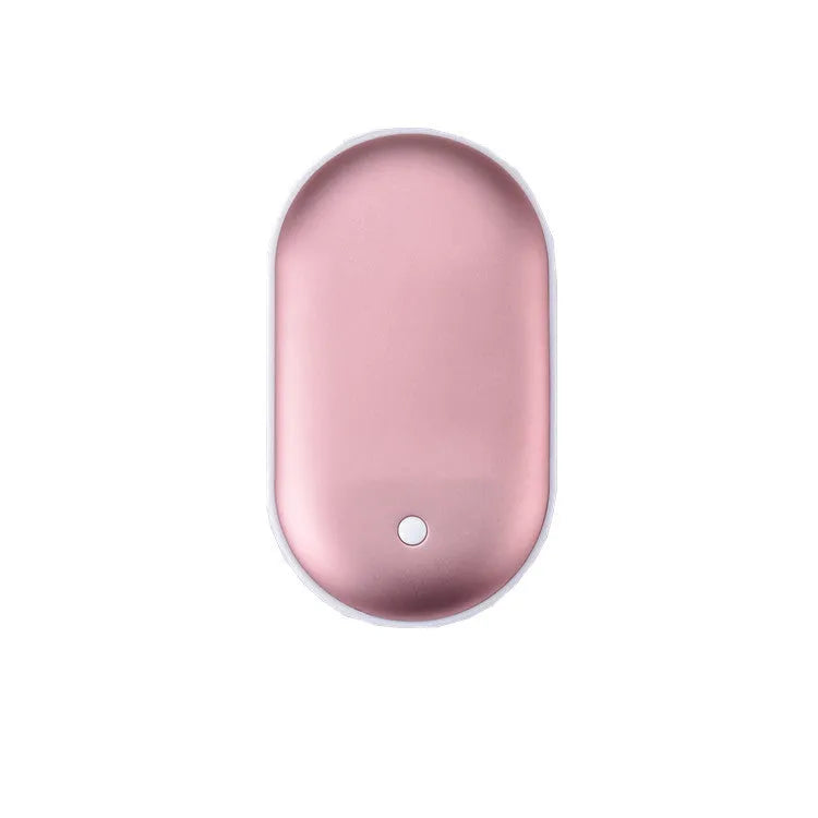 Compact rose gold USB rechargeable hand warmer and power bank with digital display on a wooden table.