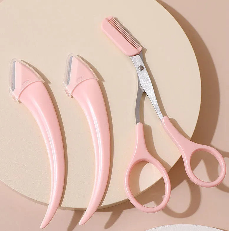 Close-up of a white and pink eyebrow trimming knife with a small curved plastic comb on a plain background.