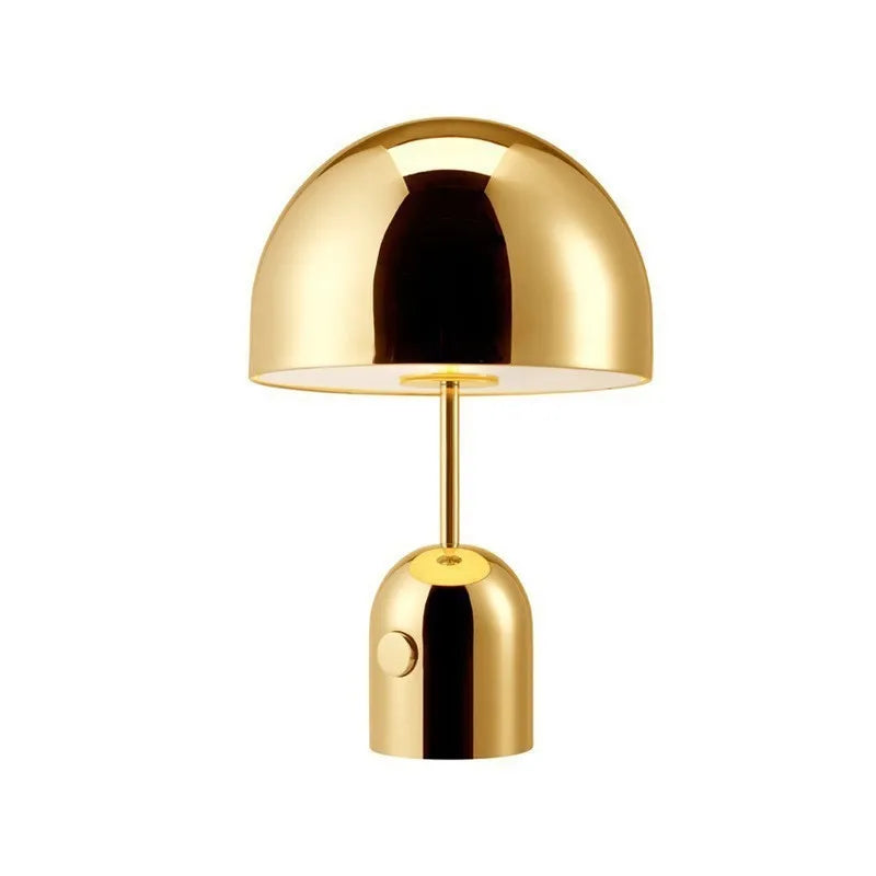 Mushroom-shaped table lamp with a metal base in rose gold finish on a wooden surface.