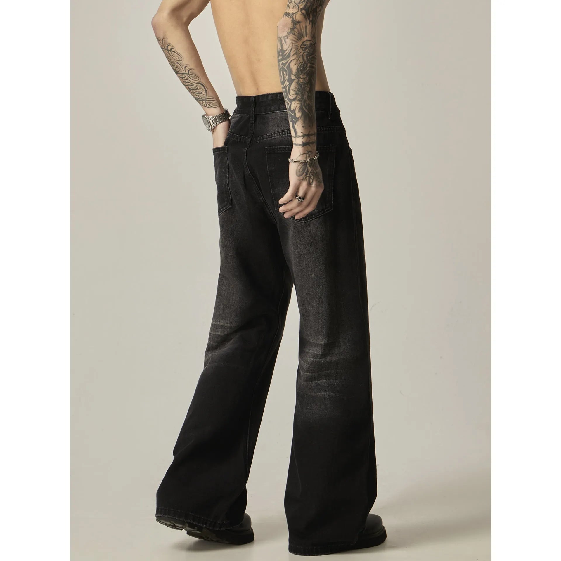 Black loose-fit straight-leg retro jeans on a mannequin, showing zip fly and casual style.
