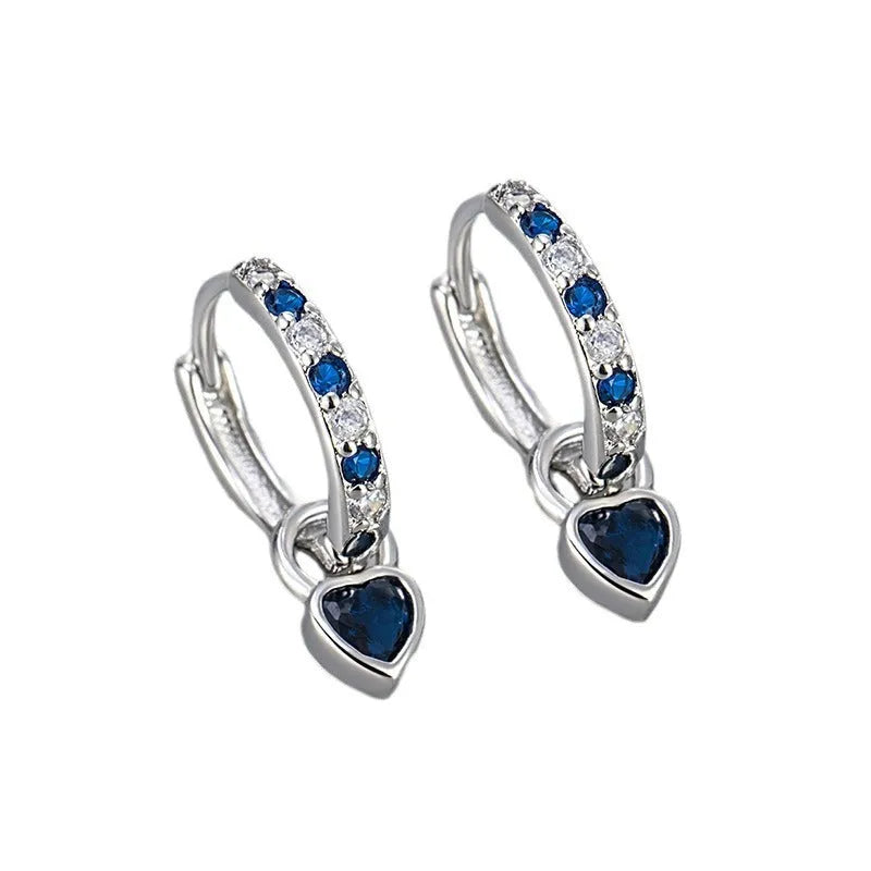 A pair of women's heart-shaped clip earrings with a coloured gemstone centre, available in gold or white gold colour metal.