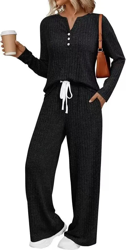 A person wearing a striped V-neck knit long coat with lace-up details and pockets, paired with matching pants.