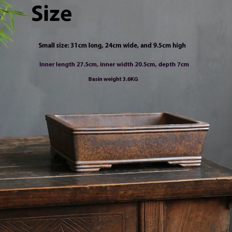 Rectangular purple sand bonsai pot with firewood burning texture on a floor.