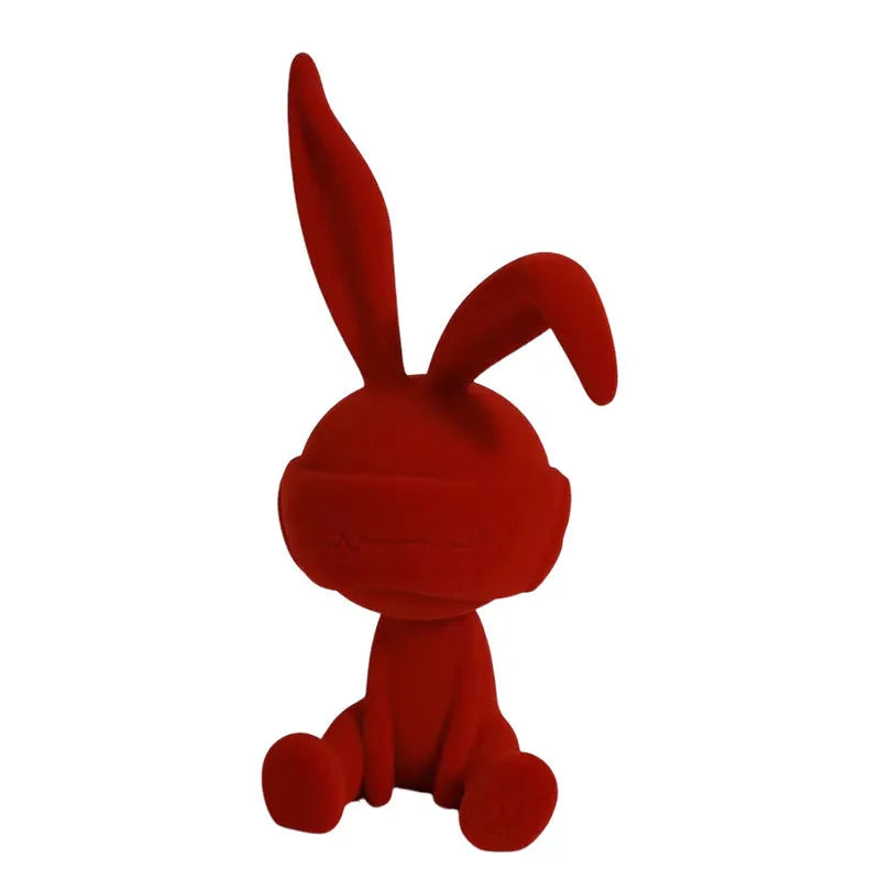Suede blindfold rabbit resin table ornament in blue, green, or red colour on a shelf.