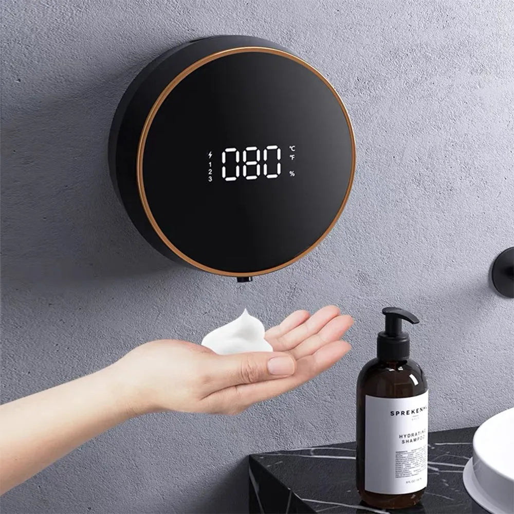 Black automatic touchless foam soap dispenser mounted on a wall with USB charging cable.
