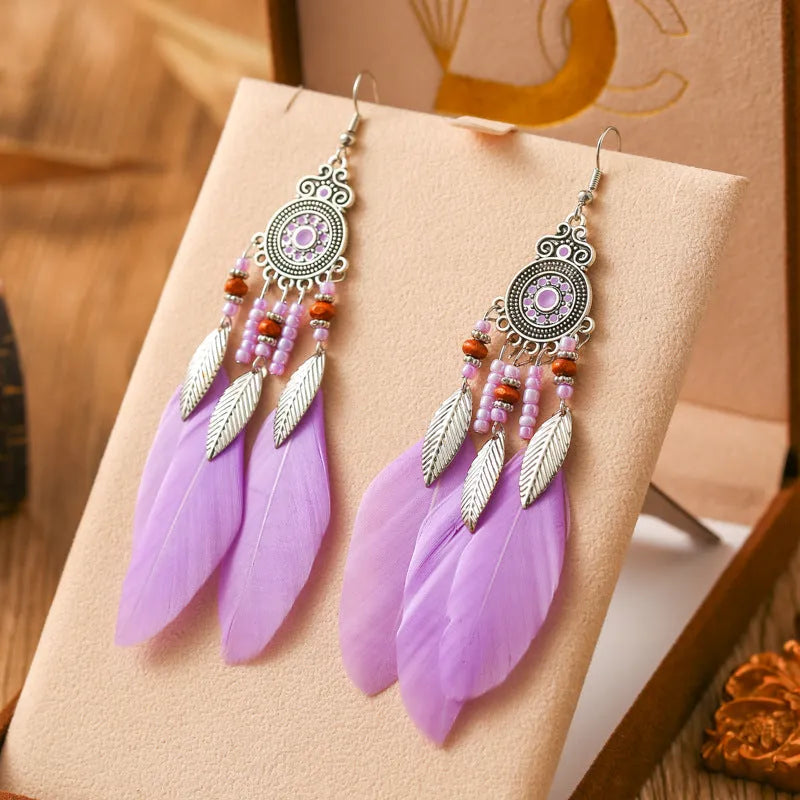 A pair of bohemian-style round drop earrings with a feather leaf pattern, shown in one of thirteen available colours.