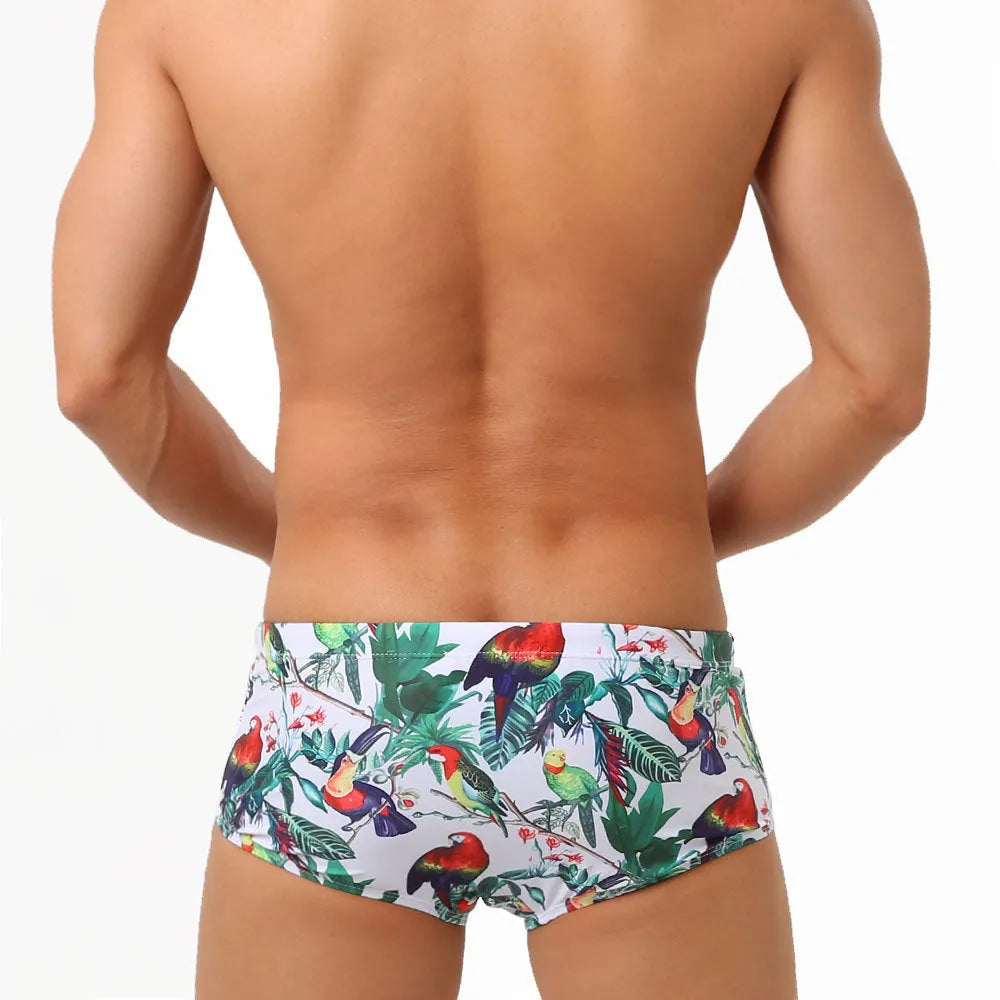 Men's floral and bird print nylon swimming trunks in boxer brief style with cup cover.