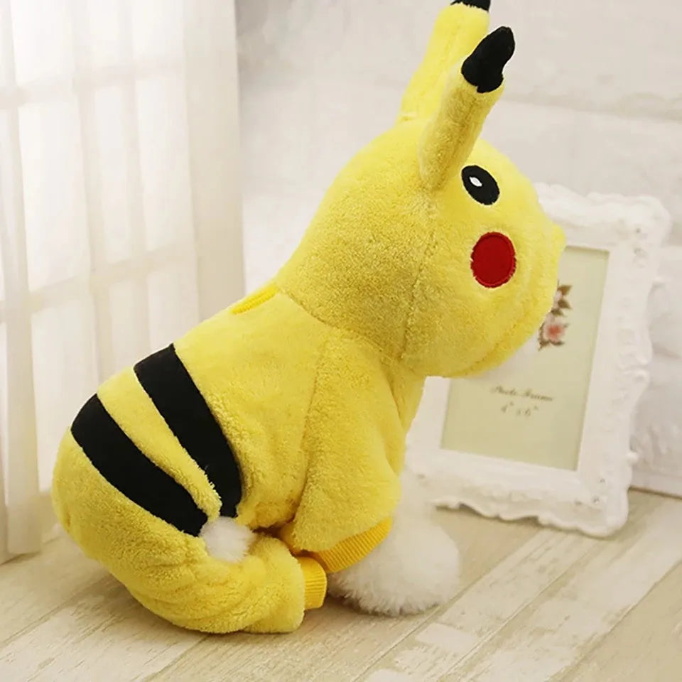 A small dog or cat wearing a cartoon-design fleece coat with a hoodie, suitable for indoor winter wear.