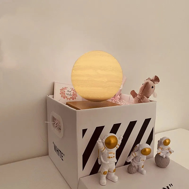 Maglev floating moon and earth night light with LED glow and small astronaut figurines on a table.