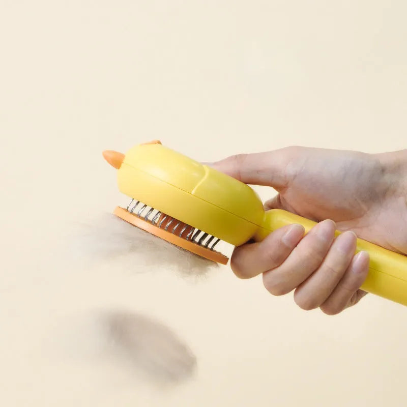 Purple pet grooming brush with stainless steel bristles and a one-button self-cleaning mechanism on a white background.