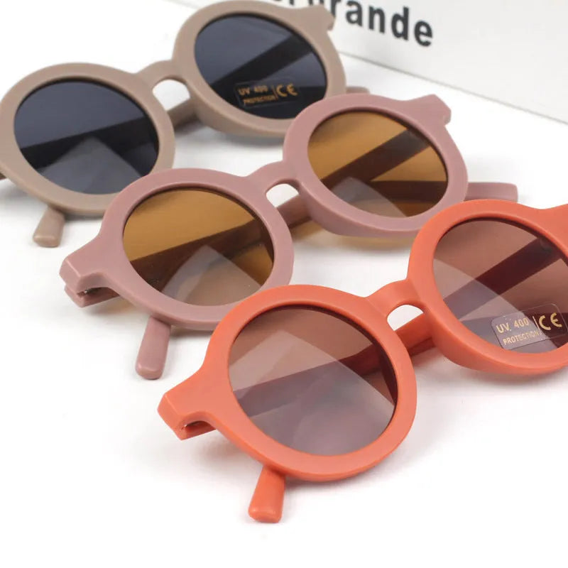 Children round frame retro mocha glasses on a child, showing the PC frame and resin lenses available in Beige, Brown, Green, Orange Red, Orange Yellow, Pink, and Purple colours