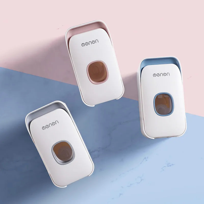 Automatic wall-mounted toothpaste dispenser in blue, grey, and pink colours with USB charging cable.
