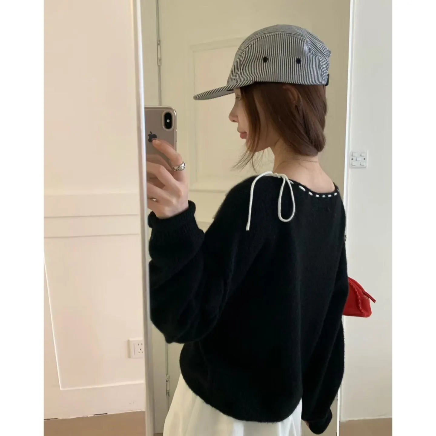 A grey women's loose-fitting long-sleeve knitwear pullover top on a hanger.