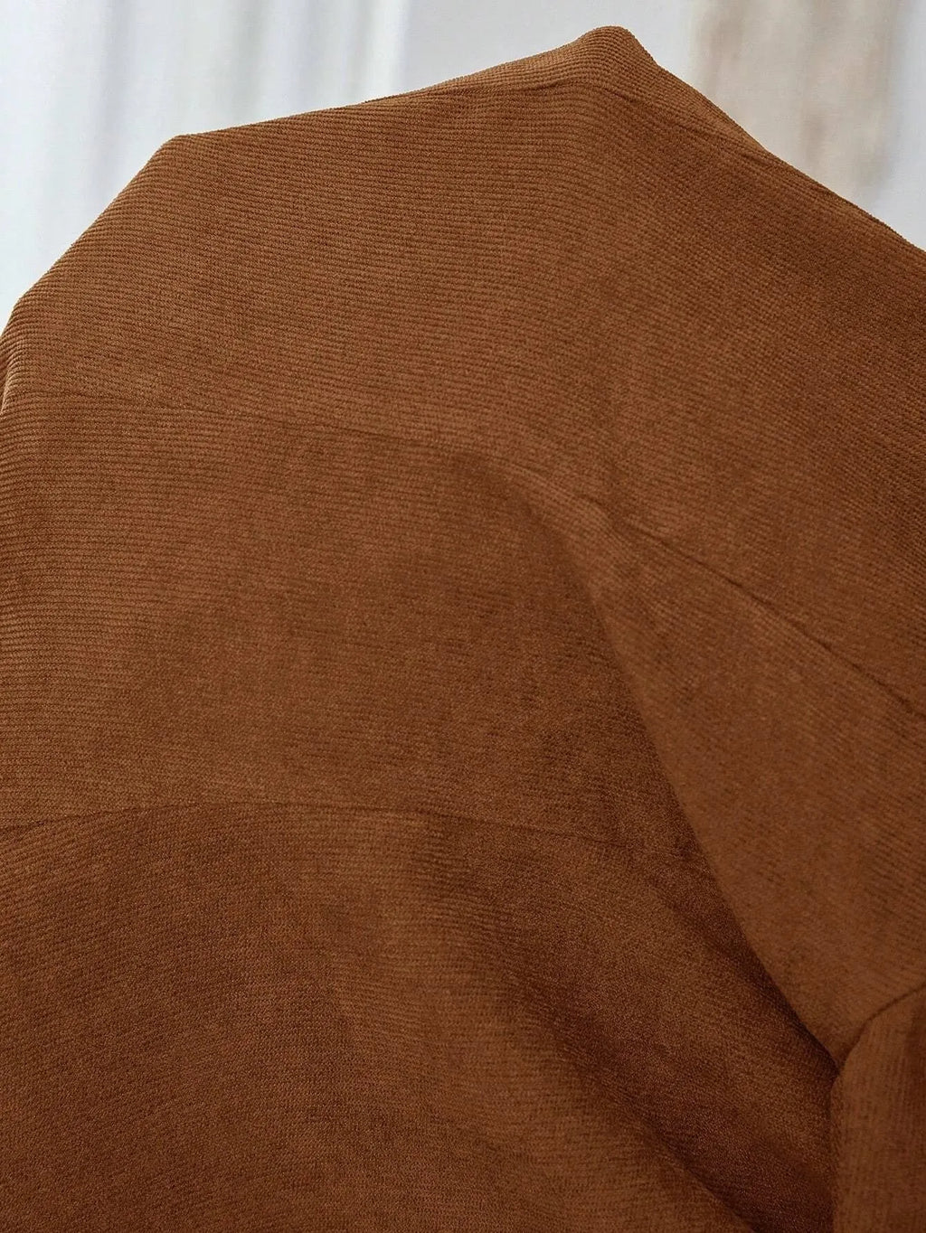 Brown men's single-breasted leisure suit coat with lapel collar on a hanger.