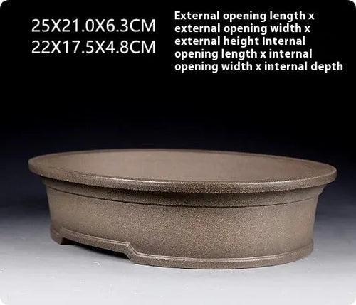 Handmade antique oval purple sand ceramic bonsai pot on a surface.