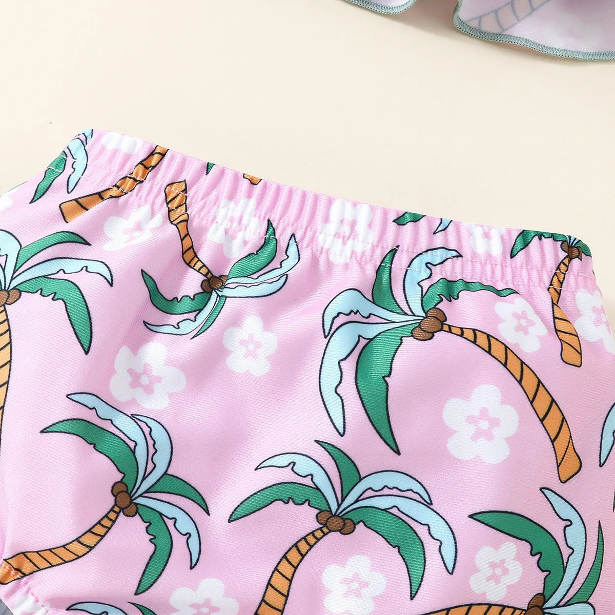 A white kids' two-piece swimsuit set consisting of a shirt and shorts, laid flat.