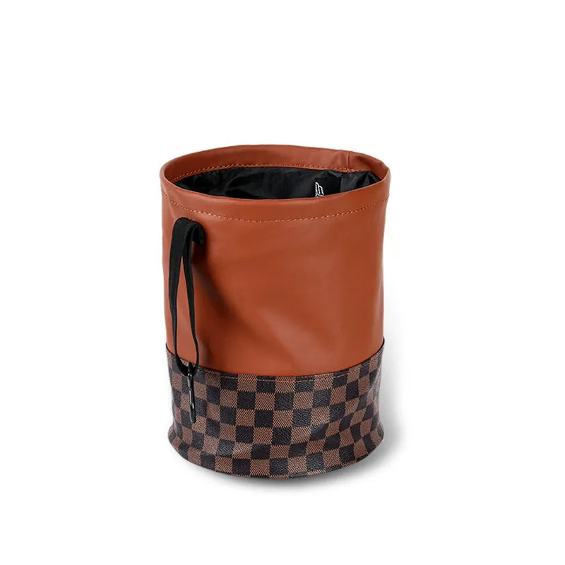 A retractable leather car trash can shown in a vehicle, featuring a carry handle.