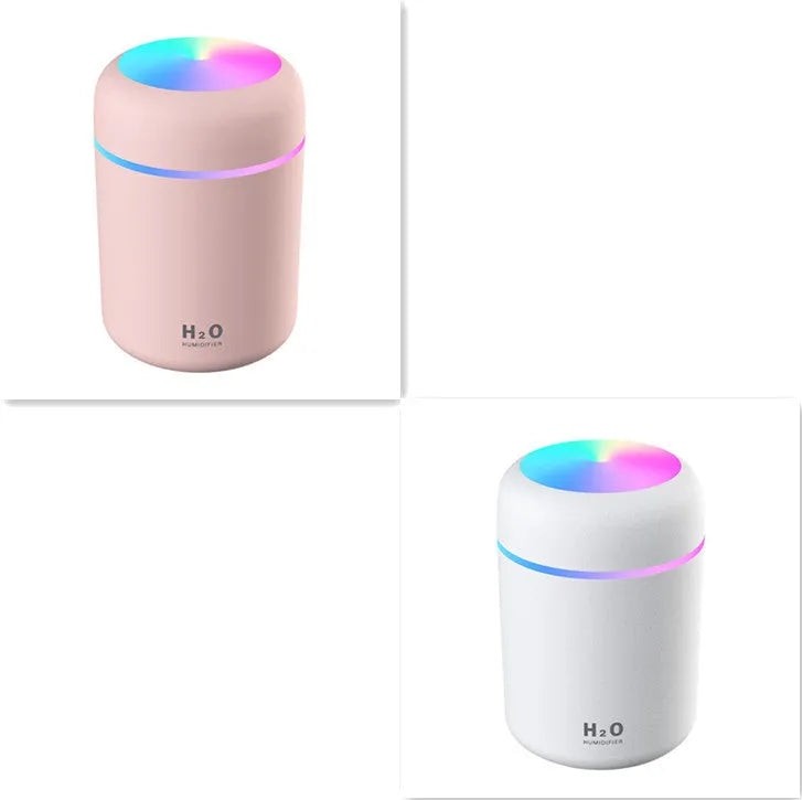 Pink USB desktop humidifier with coloured lights and water tank on a wooden desk