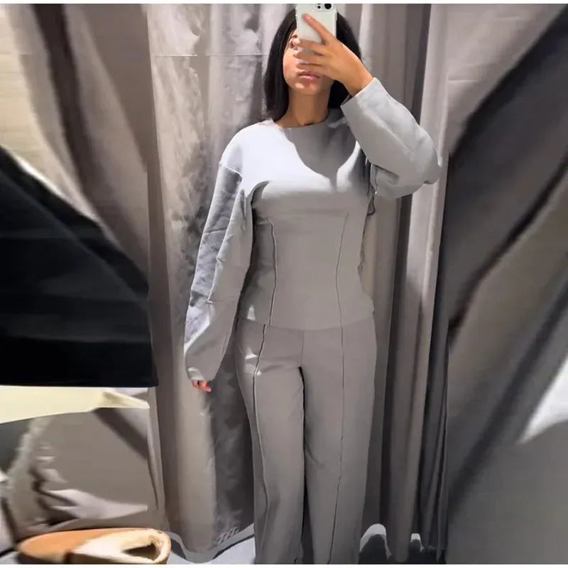 Women's black polar fleece long sleeve pleated top and wide leg trousers co-ord set on a hanger.