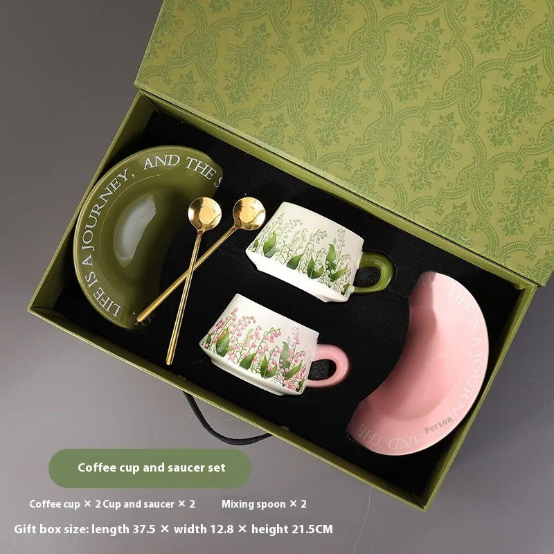 Ceramic coffee cup and saucer set with two spoons, shown in campanula and lanling grass designs.
