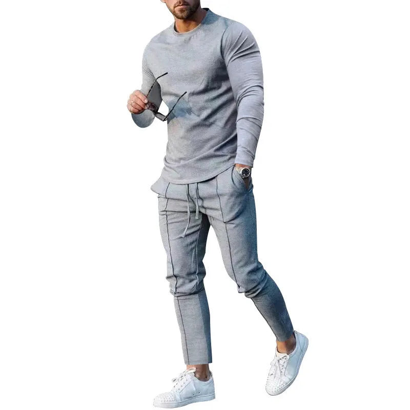 Man wearing a light grey round-neck long-sleeve t-shirt and matching trousers from a two-piece polyester suit set.