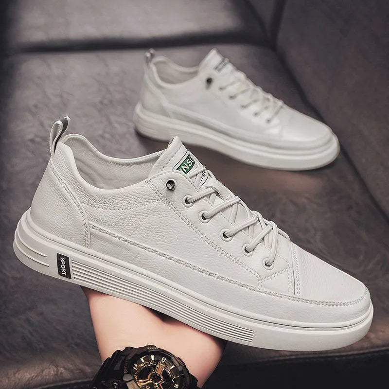 Men's white casual flat shoes with round toe and low heel on a plain background.