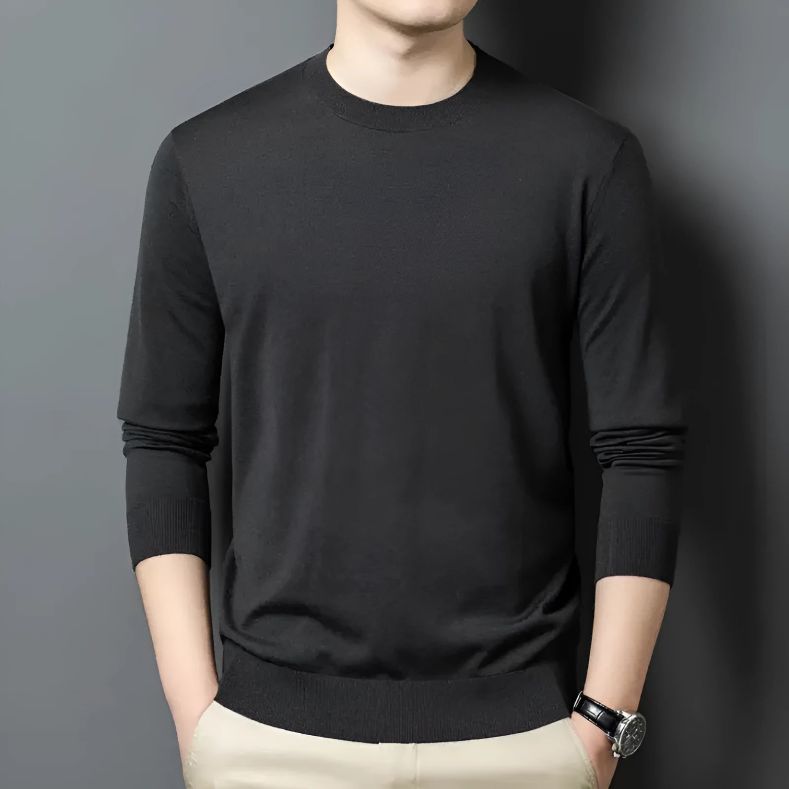 Man wearing a round neck grey wool blend sweater with long sleeves.