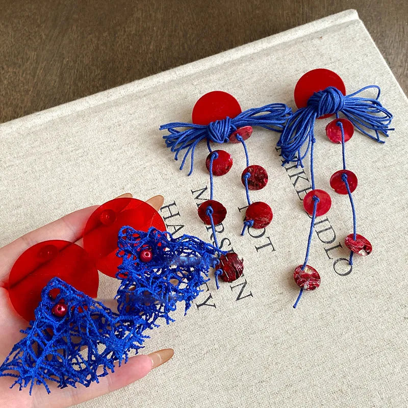 Geometric cloth hoop earrings with blue resin flower detail and manual processing