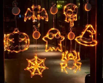 Set of seven battery-powered Halloween LED hanging lights with ghost, spider, and pumpkin designs for window decoration.