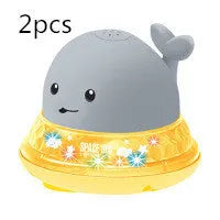 White and blue whale-shaped bath toy with water spray and LED lights floating in water