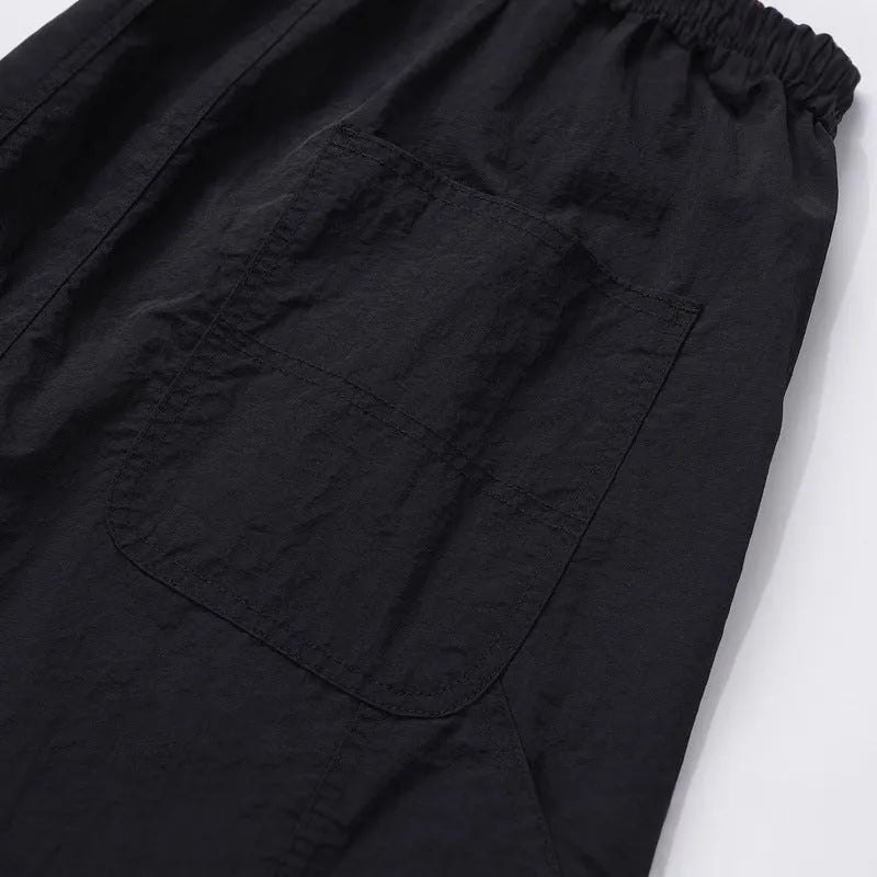 Black paratrooper pants with elastic drawstring waist and three-dimensional baggy cut