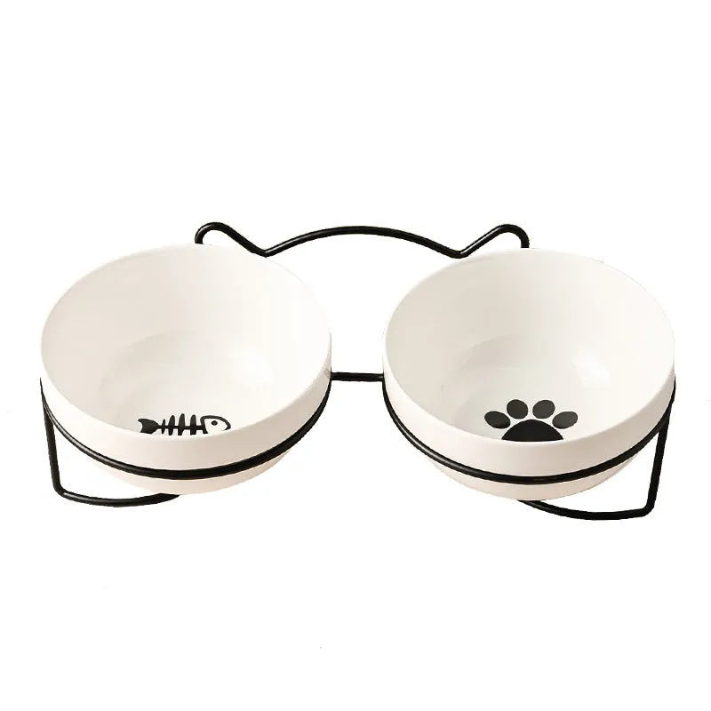 White ceramic pet bowl with cat paw design on a black metal stand with cat ear details.