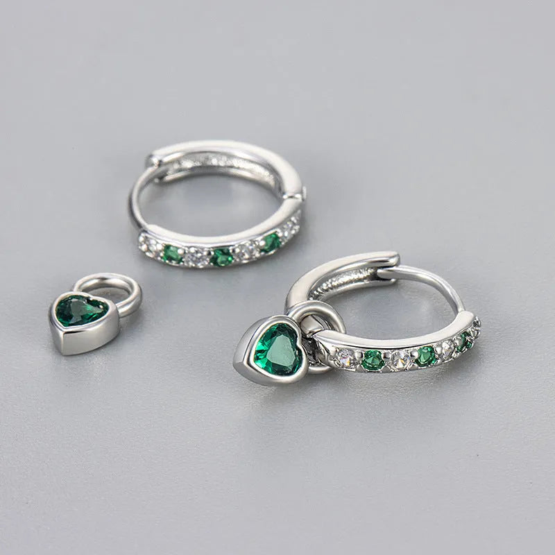 A pair of women's heart-shaped clip earrings with a coloured gemstone centre, available in gold or white gold colour metal.