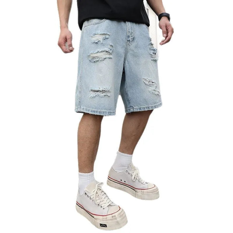 Light blue ripped denim shorts with distressed details, loose straight leg cut on a neutral background.
