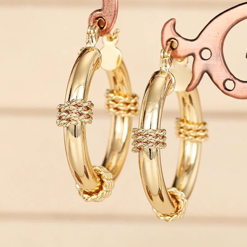 Geometric copper earrings with ring and line design in golden colour on ear