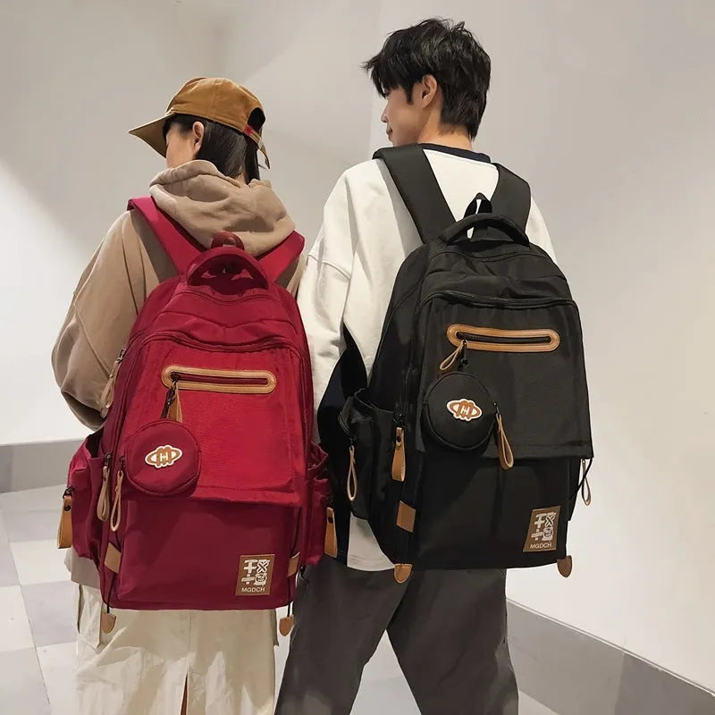 Large black nylon backpack for school with curved shoulder straps and sewing line detail