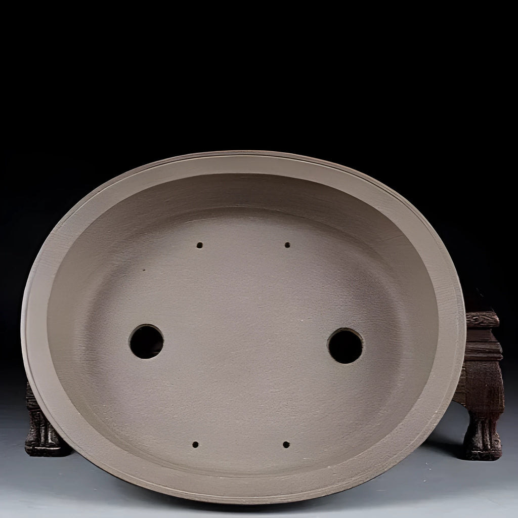 Handmade antique oval purple sand ceramic bonsai pot on a surface.