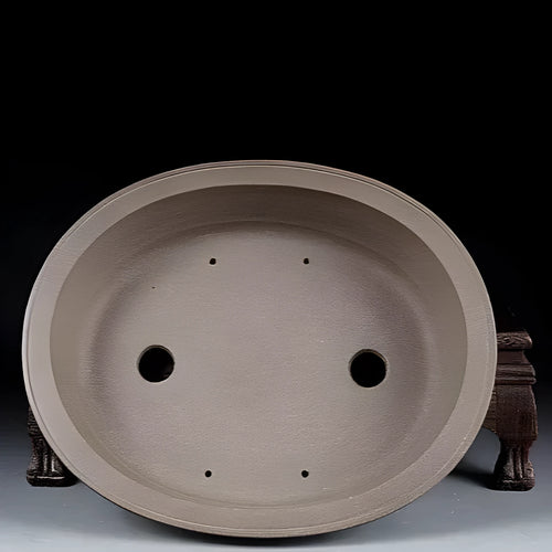 Handmade antique oval purple sand ceramic bonsai pot on a surface.