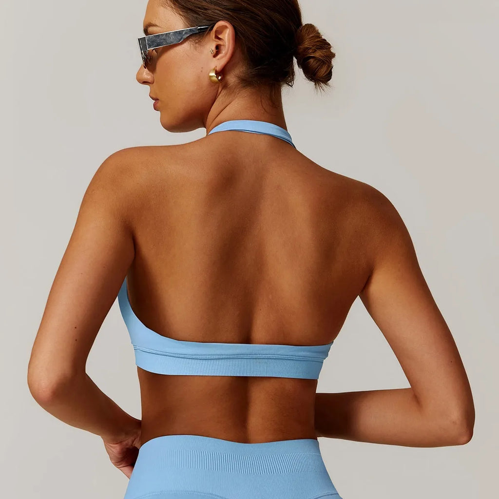 Women's black halter-neck yoga sports bra with removable padding on a mannequin.