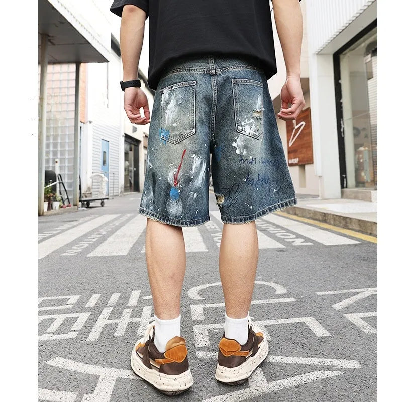 Blue ripped men's denim shorts with graffiti detail and a straight leg.
